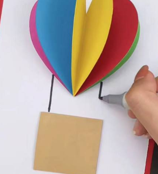 再取一张红色的彩纸,对折,开口朝右,并用黑色笔画出爱心图案的一半